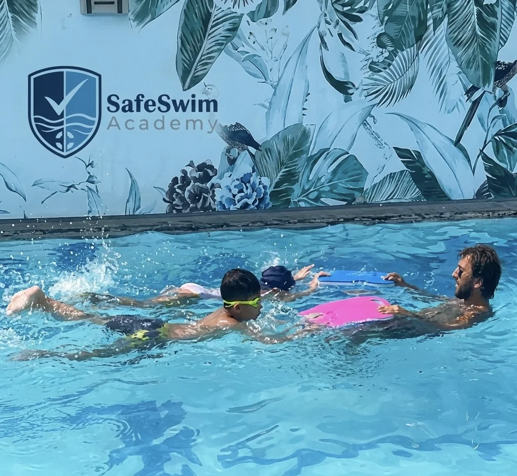 SafeSwim coach guiding multiple young swimmers in the pool